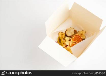 dried oranges,bananas and apples in white box on white background