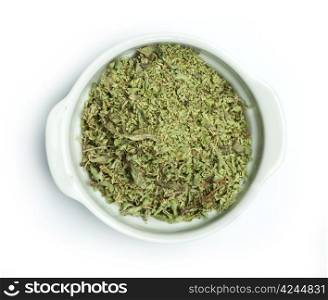Dried oregano in a bowl on white background