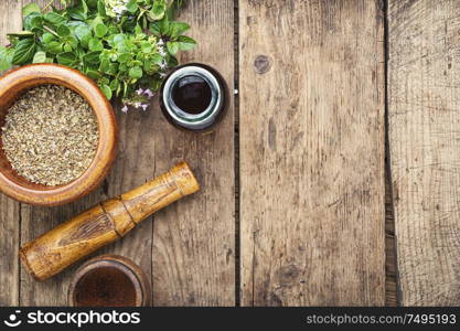 Dried oregano seasoning in a wooden mortar.Herbal medicine. Fresh and dried oregano herb