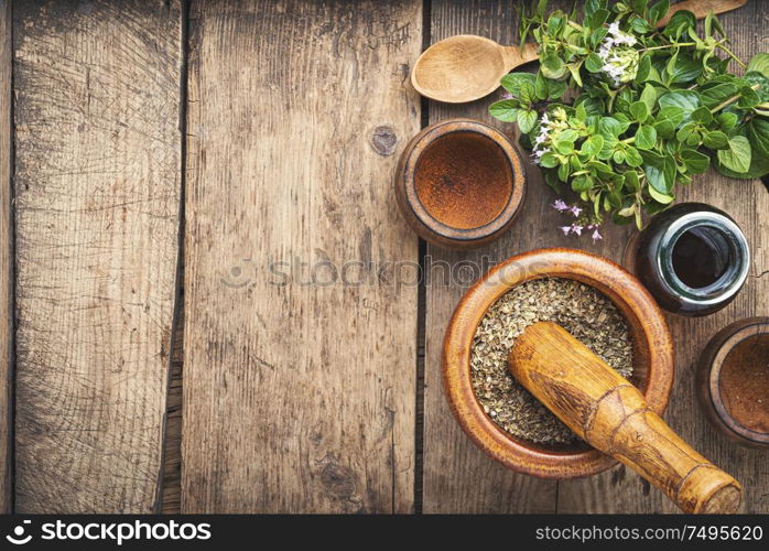 Dried oregano seasoning in a wooden mortar.Herbal medicine. Fresh and dried oregano herb