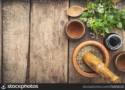 Dried oregano seasoning in a wooden mortar.Herbal medicine. Fresh and dried oregano herb