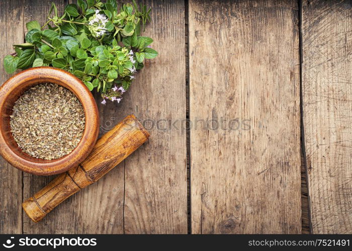 Dried oregano seasoning in a wooden mortar.Herbal medicine. Fresh and dried oregano or marjoram