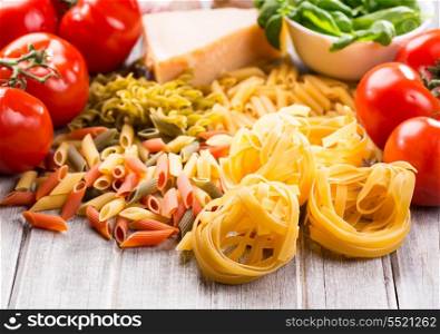 dried pasta and vegetables on wooden table
