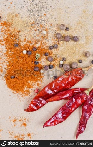 dried peppers and other kind of peppers spices on a brown background