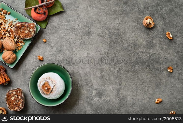 Dried persimmons stuffed with walnuts on a dark table with copy space. Top view of sweet fruit persimmon dessert. Traditional dessert of oriental cuisine.