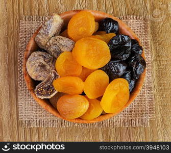 Dried pitted fruits on a wooden background