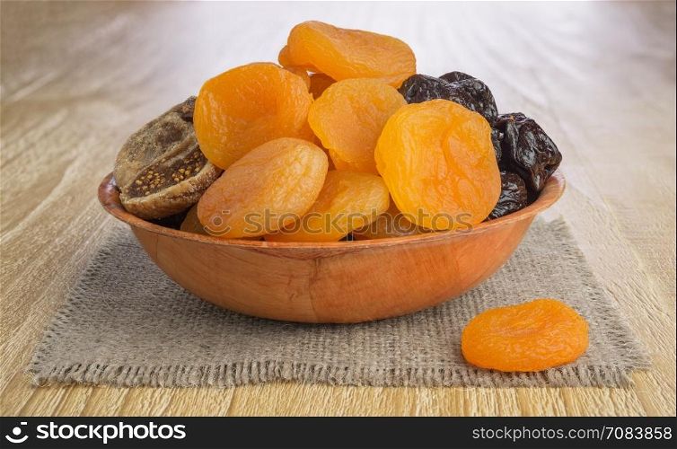 Dried pitted fruits on a wooden background