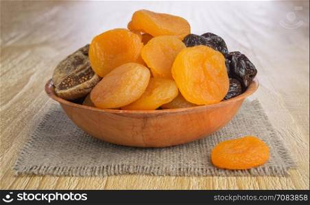Dried pitted fruits on a wooden background