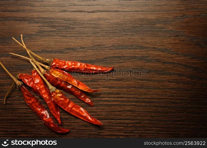 Dried red hot peppers sitting on a table top. Lots of area for text.