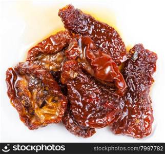 dried red tomatoes in olive oil on white background