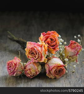 Dried rose on wooden table