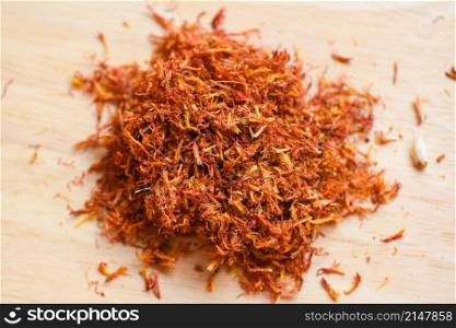 Dried safflower for herbal tea on wooden background, dry safflower petals, Saffron substitute