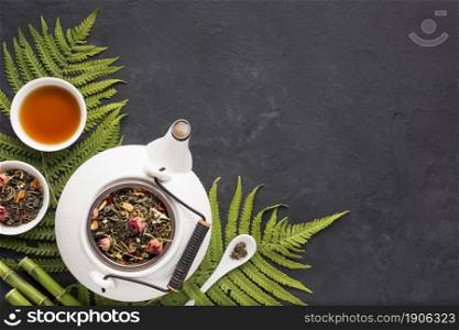 dried tea herb with fern leaves bamboo stick black textured backdrop. High resolution photo. dried tea herb with fern leaves bamboo stick black textured backdrop. High quality photo