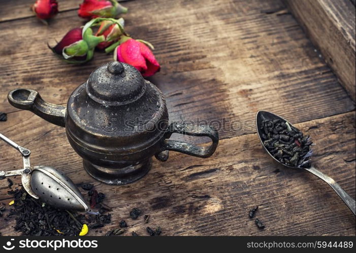 Dried tea leaves. Stylish spoons with variety of tea on vintage wooden board.