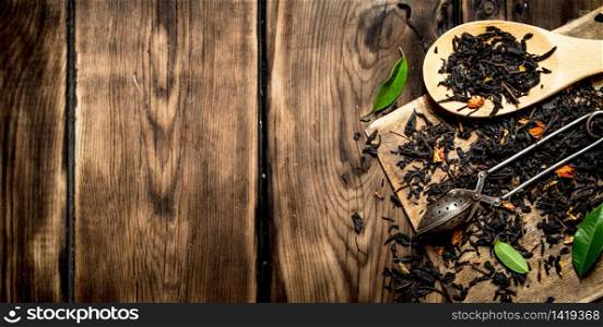 dried tea with spoons. On wooden background.. dried tea with spoons.