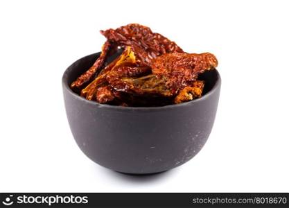 dried tomatoes in stone bowl close up on white background