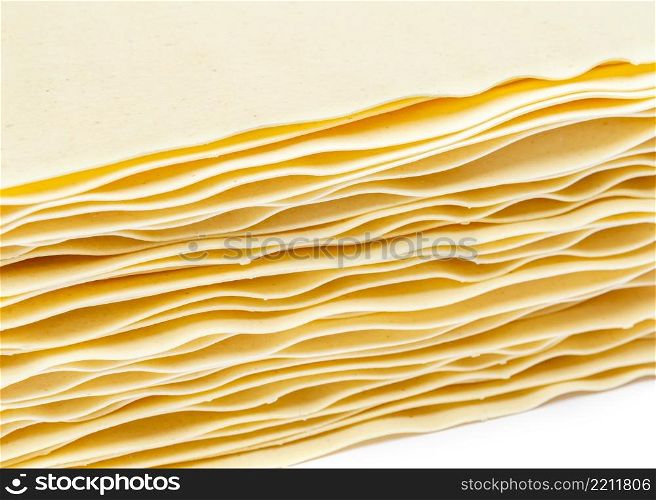 dried uncooked lasagna pasta sheets isolated over the white background. dried uncooked lasagna pasta sheets