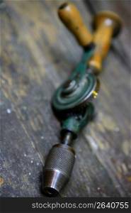 Drill tool old style with hand human energy in green over wood table