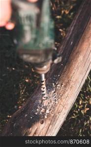 Drilling hole in timber while working in garden