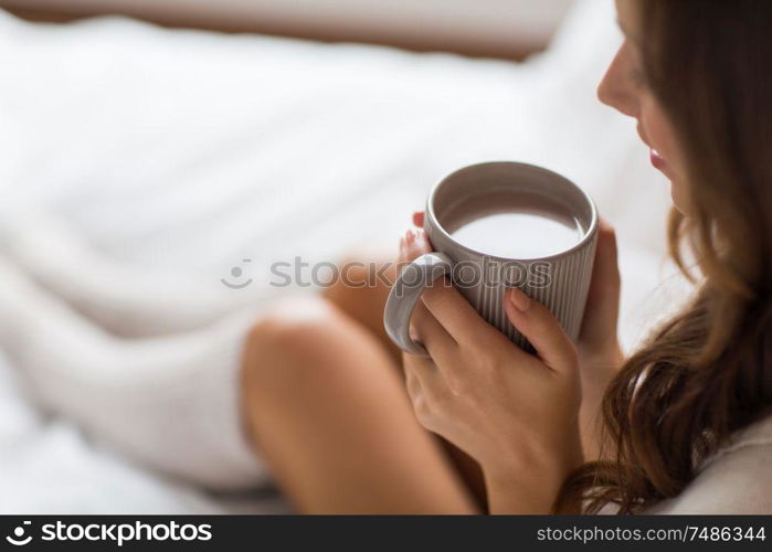 drink, christmas and hygge concept - close up of happy woman with cup of coffee at home. close up of happy woman with cup of coffee at home