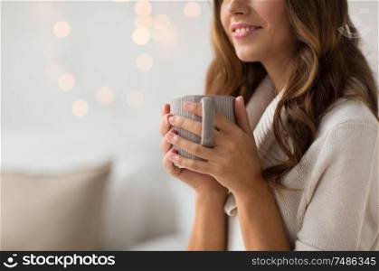 drink, christmas and hygge concept - close up of happy woman with cup of coffee or tea at home. close up of happy woman with cup of coffee at home