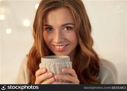 drink, christmas, winter, holidays and people concept - close up of happy young woman with cup of coffee or tea at home