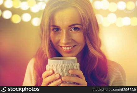 drink, christmas, winter, holidays and people concept - close up of happy young woman with cup of coffee or tea at home. close up of woman with tea or coffee cup at home