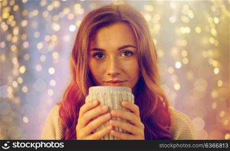 drink, christmas, winter, holidays and people concept - happy young woman with cup of coffee or tea at home. happy woman with cup of tea or coffee at home