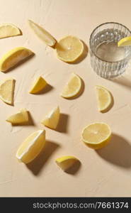 drink, detox and vitaminic concept - glass of water and lemon slices on table. glass of water and lemon slices on table