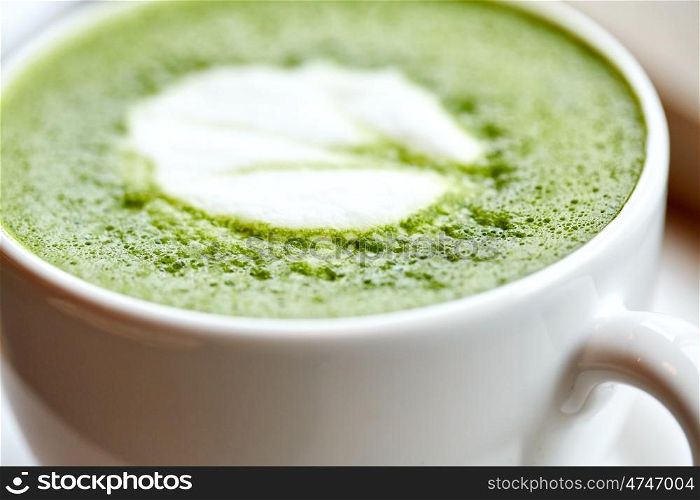 drink, diet, weight-loss and slimming concept - close up of white cup of matcha green tea latte on table at restaurant or cafe