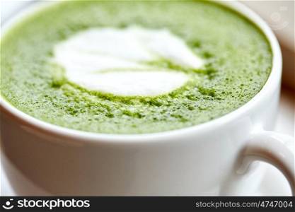 drink, diet, weight-loss and slimming concept - close up of white cup of matcha green tea latte on table at restaurant or cafe