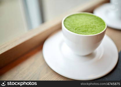 drink, diet, weight-loss and slimming concept - white cup of matcha green tea latte on table at restaurant or cafe