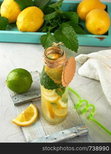 drink lemonade in a glass bottle and ripe fresh lemons, top view