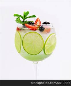 Drink with berries, with lime slices and mint in a wine glass