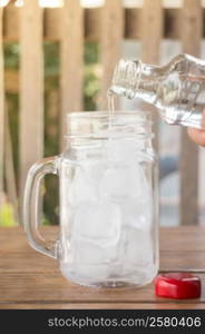 Drinking water is poured into iced glass, stock photo