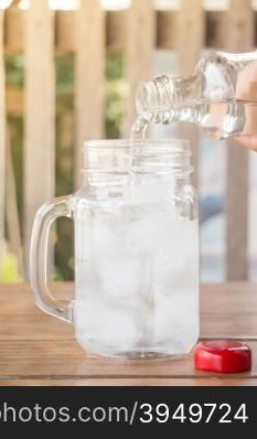 Drinking water is poured into iced glass, stock photo