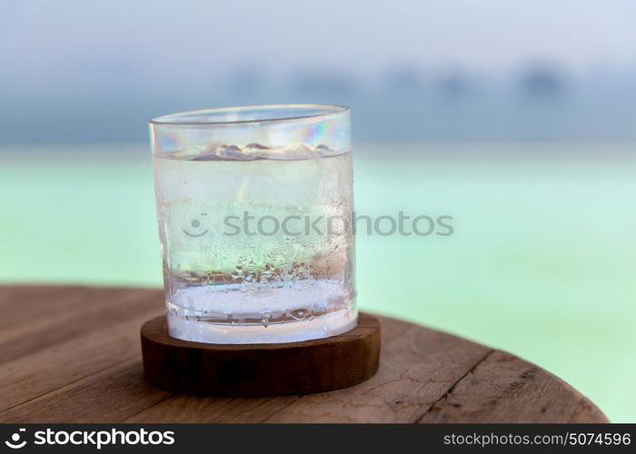 drinks and luxury concept - glass with cold water or cocktail on bar table. glass with cold water or cocktail on bar table