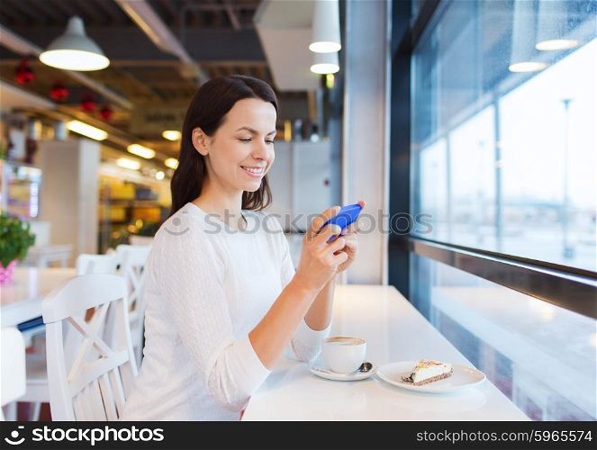 drinks, food, people, technology and lifestyle concept - smiling young woman with smartphone drinking coffee at cafe