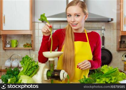Drinks good for health, diet breakfast concept. Young woman in kitchen making green healthy vegetable smoothie juice from green vegetables. Woman in kitchen making vegetable smoothie juice