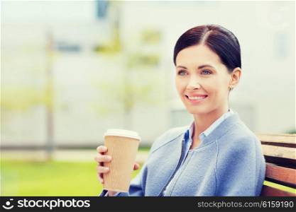 drinks, leisure and people concept - smiling woman drinking coffee outdoors
