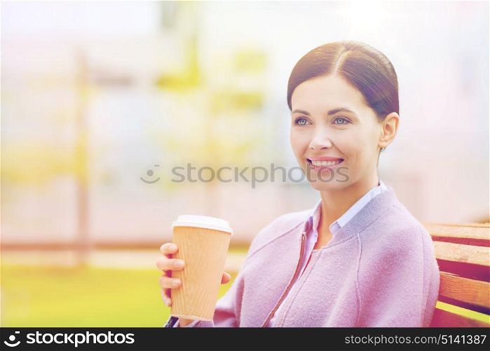 drinks, leisure and people concept - smiling woman drinking coffee outdoors. smiling woman drinking coffee outdoors