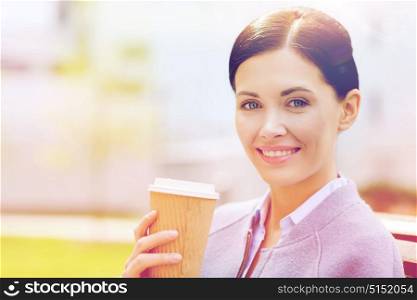 drinks, leisure and people concept - smiling woman drinking coffee outdoors. smiling woman drinking coffee outdoors