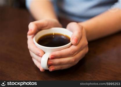 drinks, people and lifestyle concept - close up of woman hands holding cup with hot black coffee