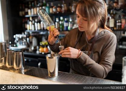 drinks, people and luxury concept - barmaid with shaker pouring alcohol from bottle into jigger and preparing cocktail at bar. barmaid with shaker preparing cocktail at bar