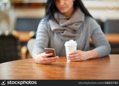 drinks, people, technology and lifestyle concept - close up of woman with smartphone and coffee at cafe