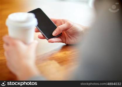 drinks, people, technology and lifestyle concept - close up of woman with smartphone and coffee at cafe