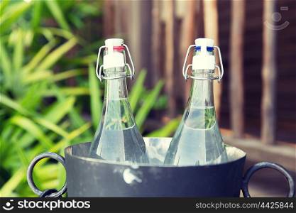 drinks, thirst, refreshment and summer resort concept - couple of water bottles in ice bucket at hotel