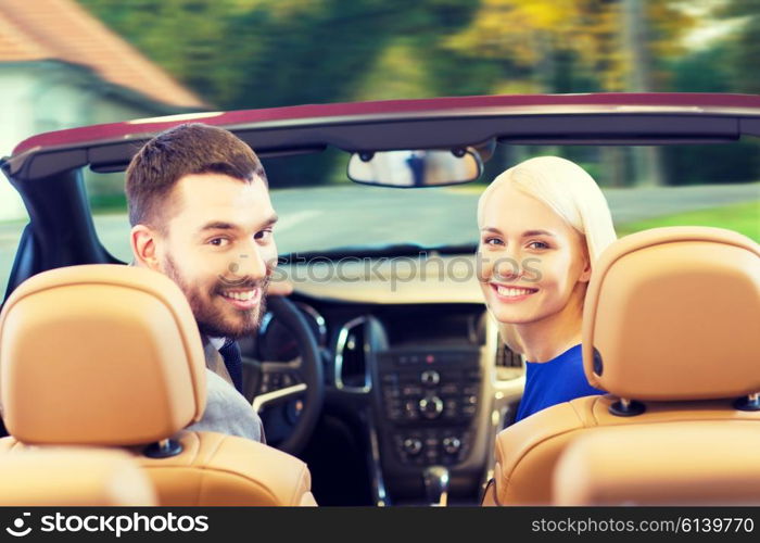 drive, auto transport and people concept - close up of happy couple driving in cabriolet car from back over city street background