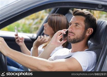 driver and co-pilot using a mobile phone in a car