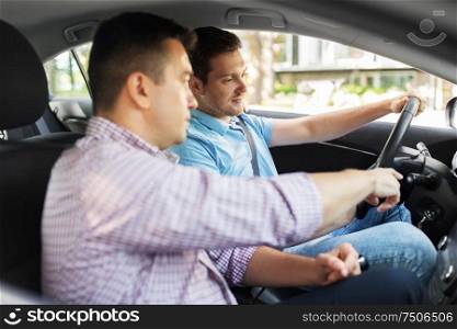 driver courses and people concept - car driving school instructor teaching young man to drive. car driving school instructor teaching male driver